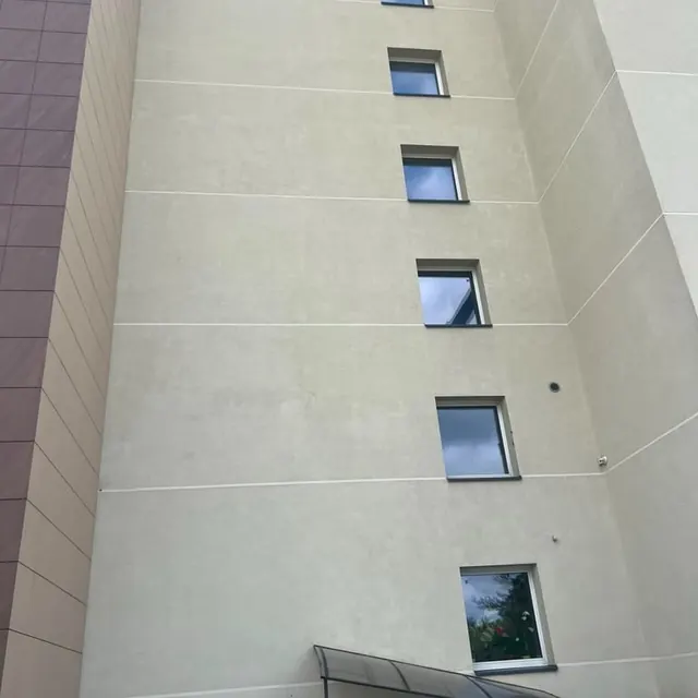 Aukšto pastato fasadas po valymo